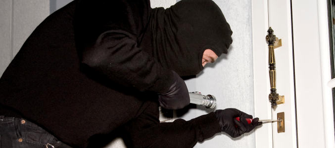 Un ladrón intenta forzar una puerta para robar