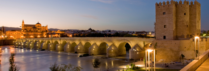 Vista nocturna del Puente Romano sobre el Guadalquivir en Córdoba