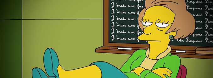 Edna Krabappel sentada en su mesa