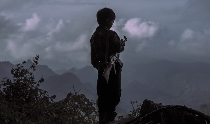 Chi Vang de 10 años sujetando un AK-47