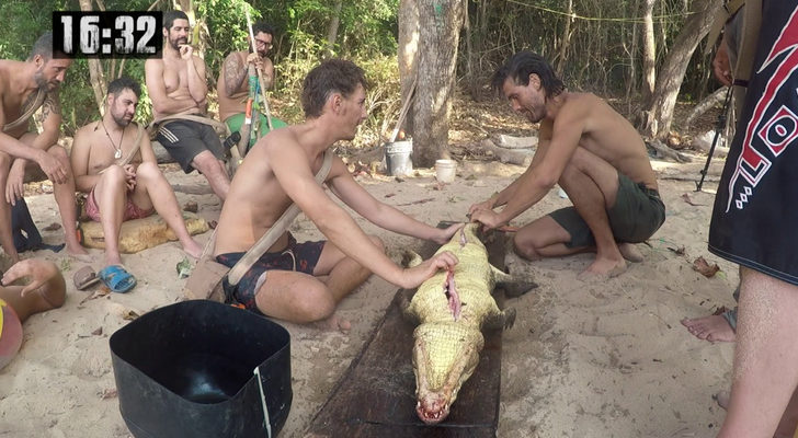 Participantes de 'La isla' con el caimán muerto