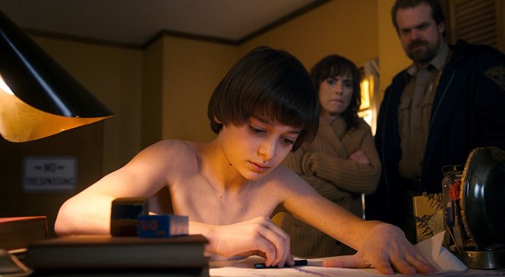 Will realizando uno de sus extraños dibujos ante la mirada de su madre en &#39;Stranger Things&#39;