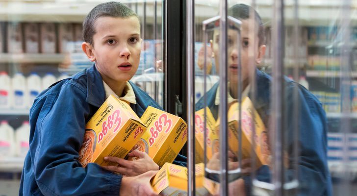 Once o Eleven, interpretada por Millie Bobbie Brown en un supermercado con varias cajas de gofres (waffles) en la primera temporada de &#39;Stranger Things&#39;, de Netflix